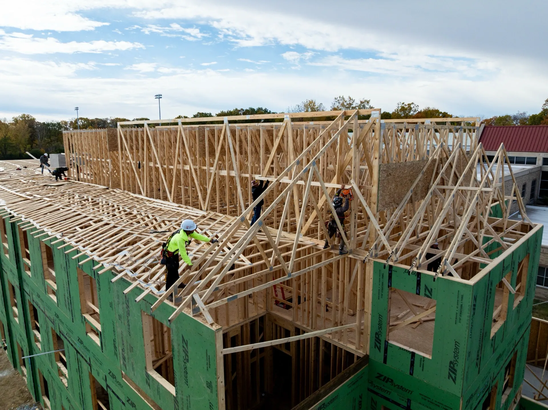 Construction workers installing roof trusses at Holy Cross College.