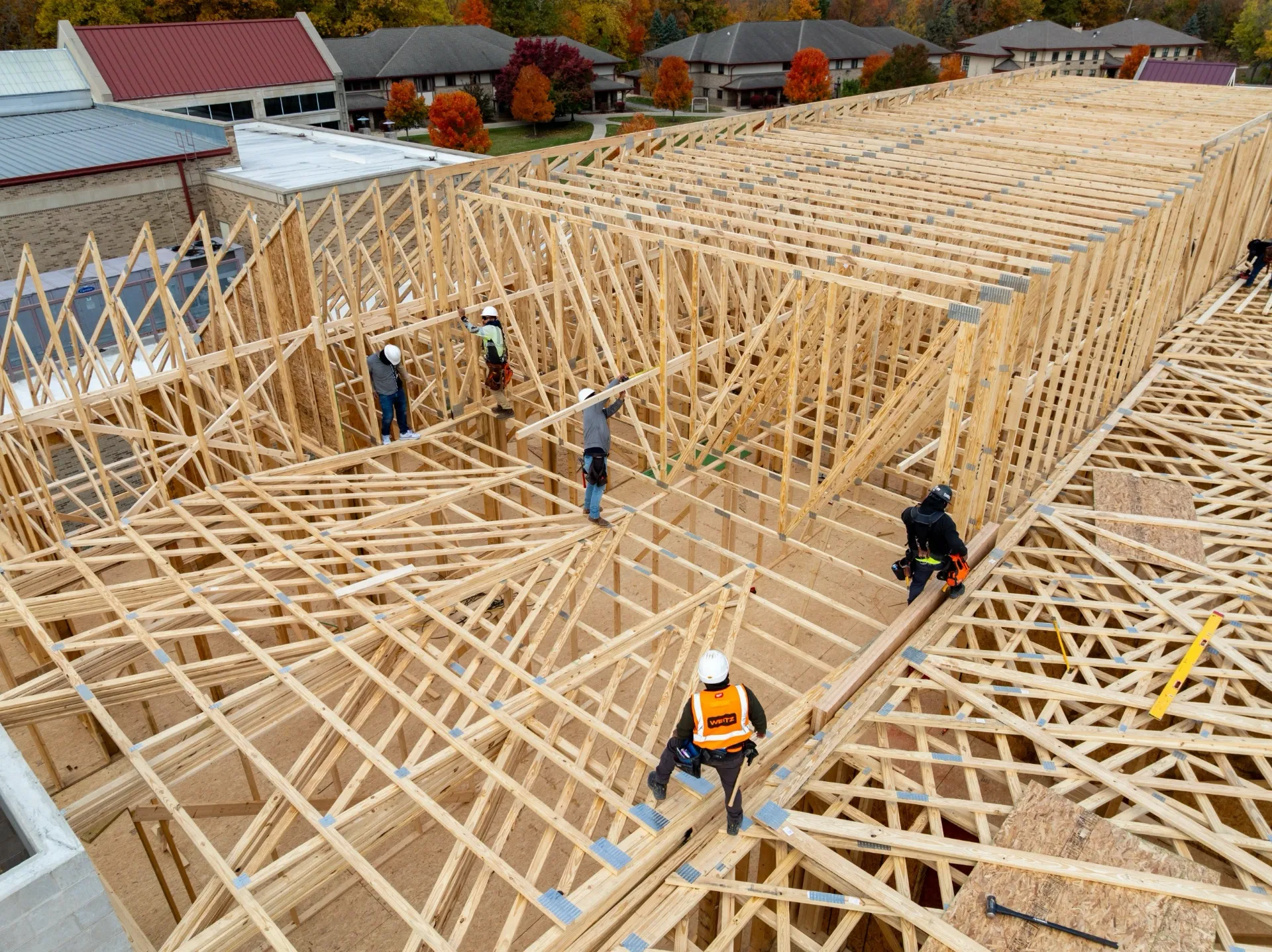 Construction workers installing roof trusses.