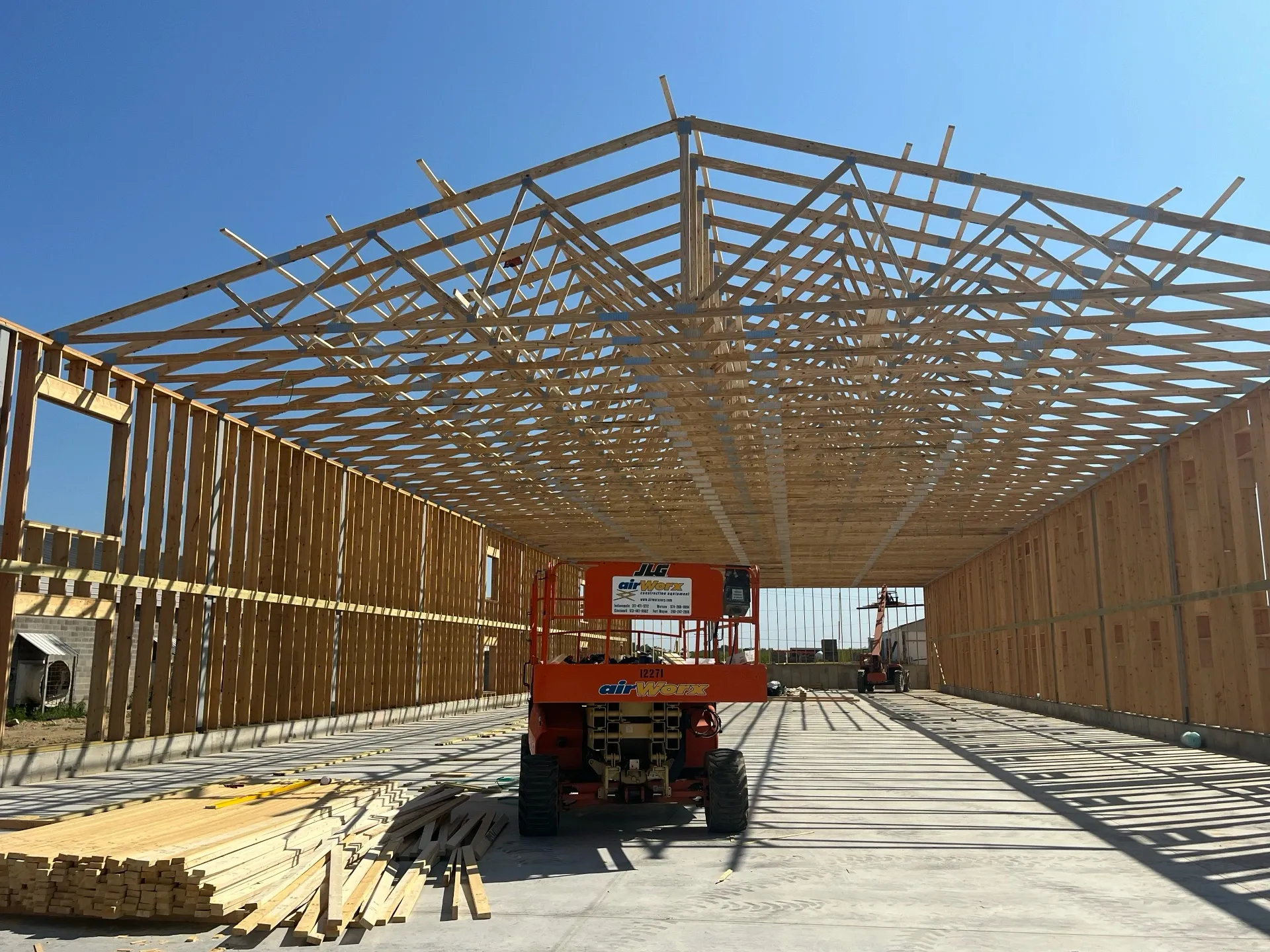 Partially installed roof trusses on a shop.
